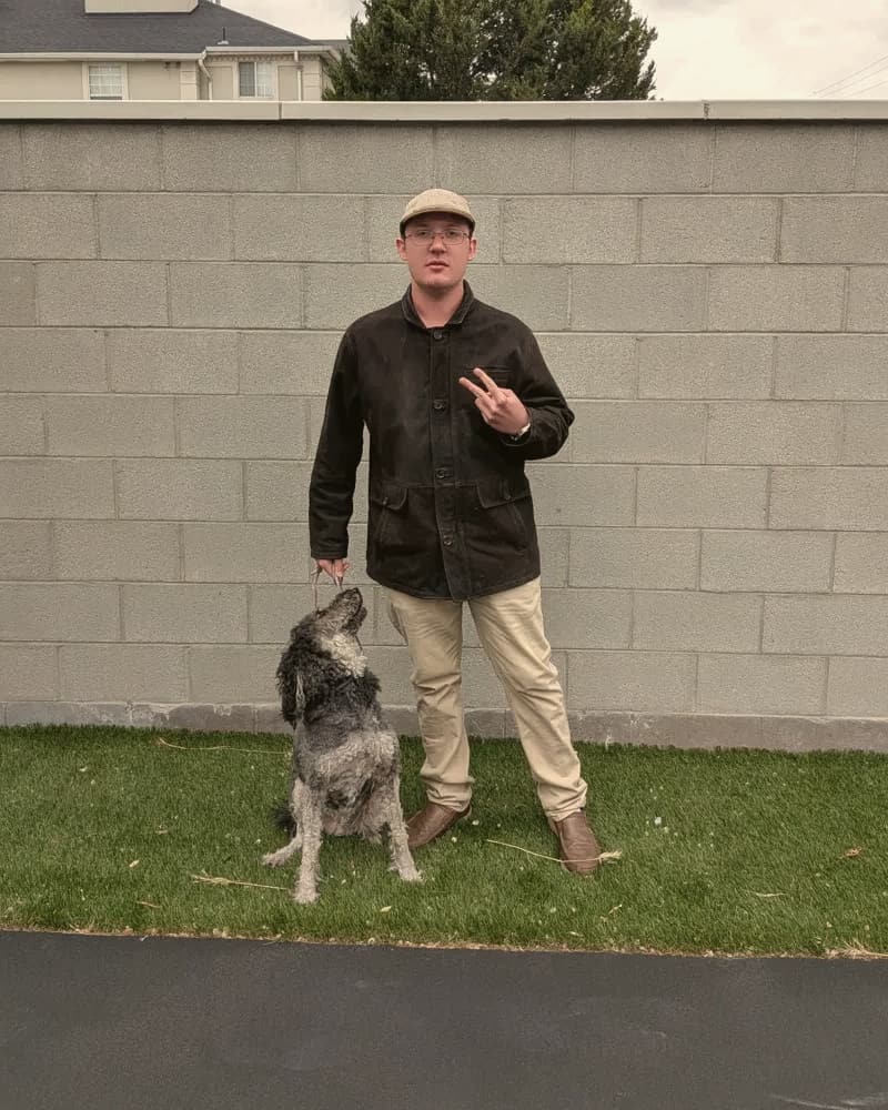 Bryce Esau, Christian poet and founder of The Heart’s Quill, standing on a lawn with his dog.